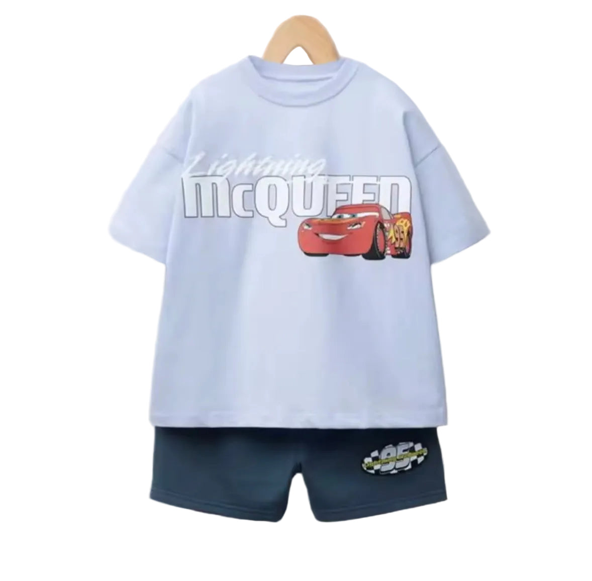 Light blue t-shirt with 'Lightning McQueen' and navy shorts on a beige background