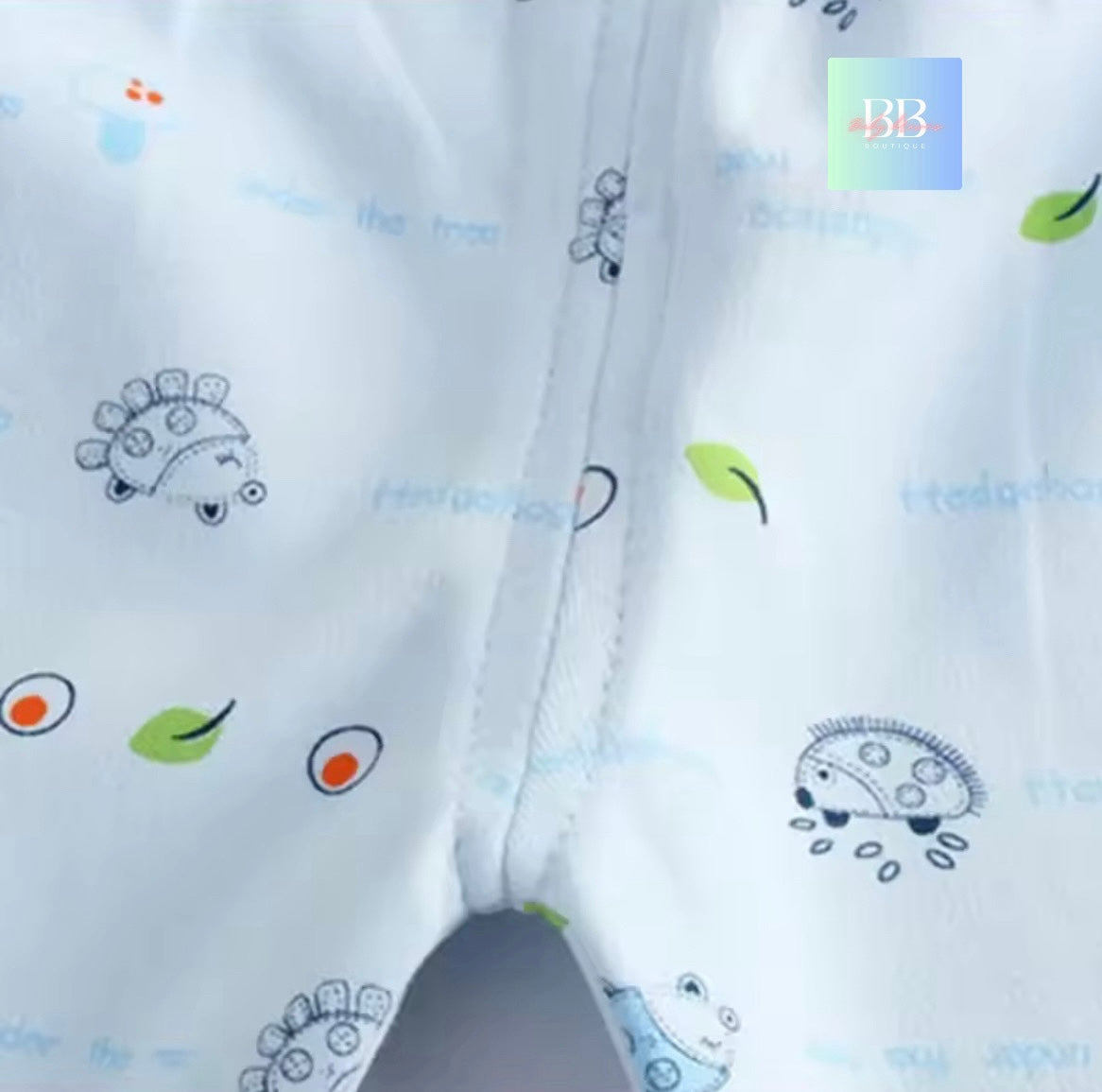 Close-up of white fabric with colorful embroidered designs on a white background.