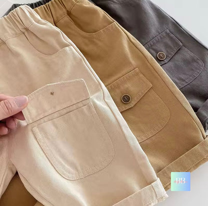 Three pairs of pants in beige, brown, and gray on a white background.