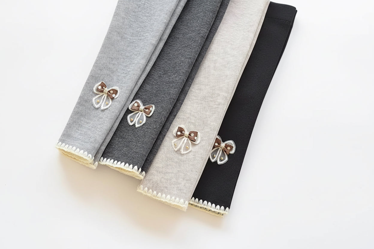 Three fabric swatches with decorative bows on a white surface