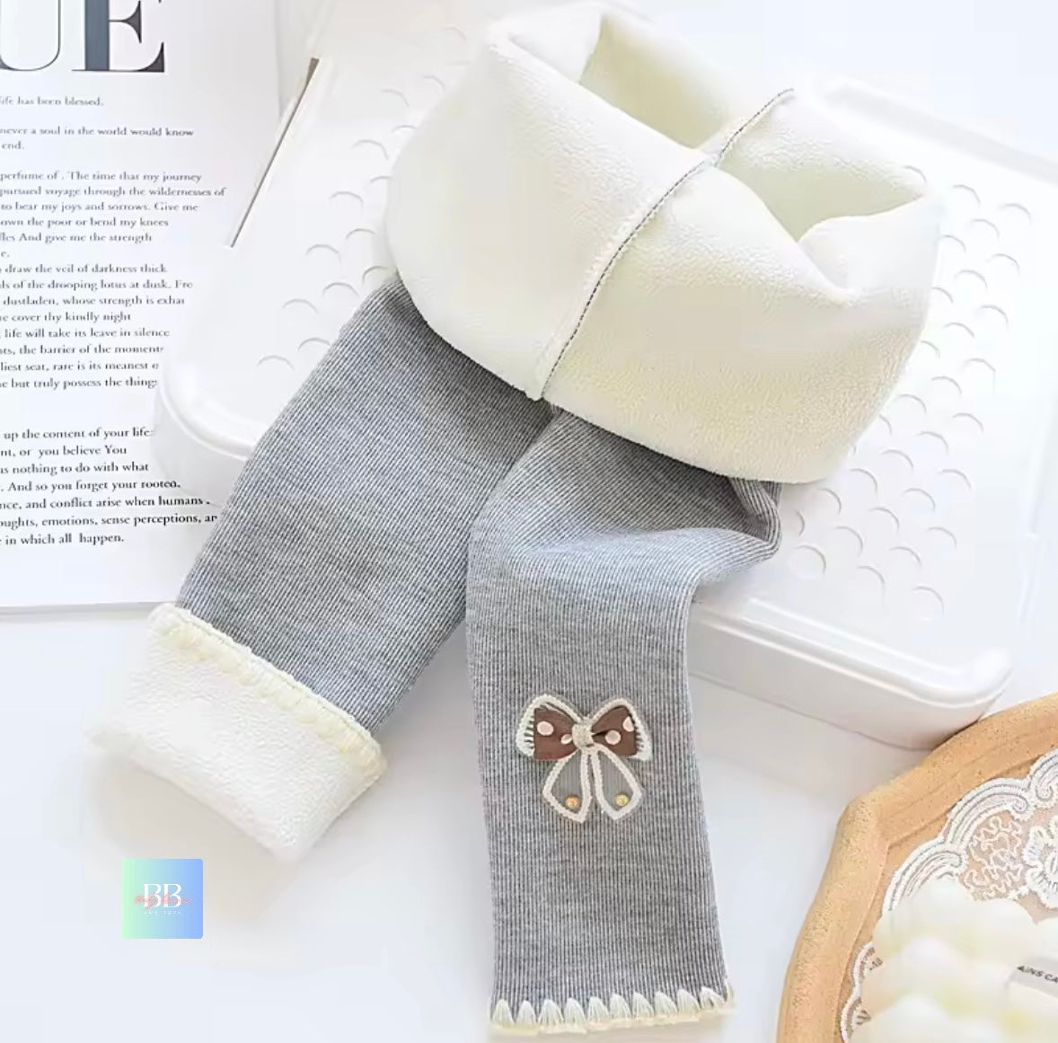Gray knee-high socks with white cuffs and a bow detail on a magazine page.