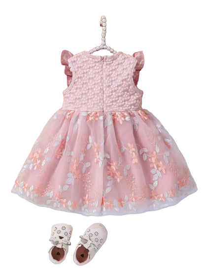 Pink floral dress on a hanger with shoes and flowers in the background
