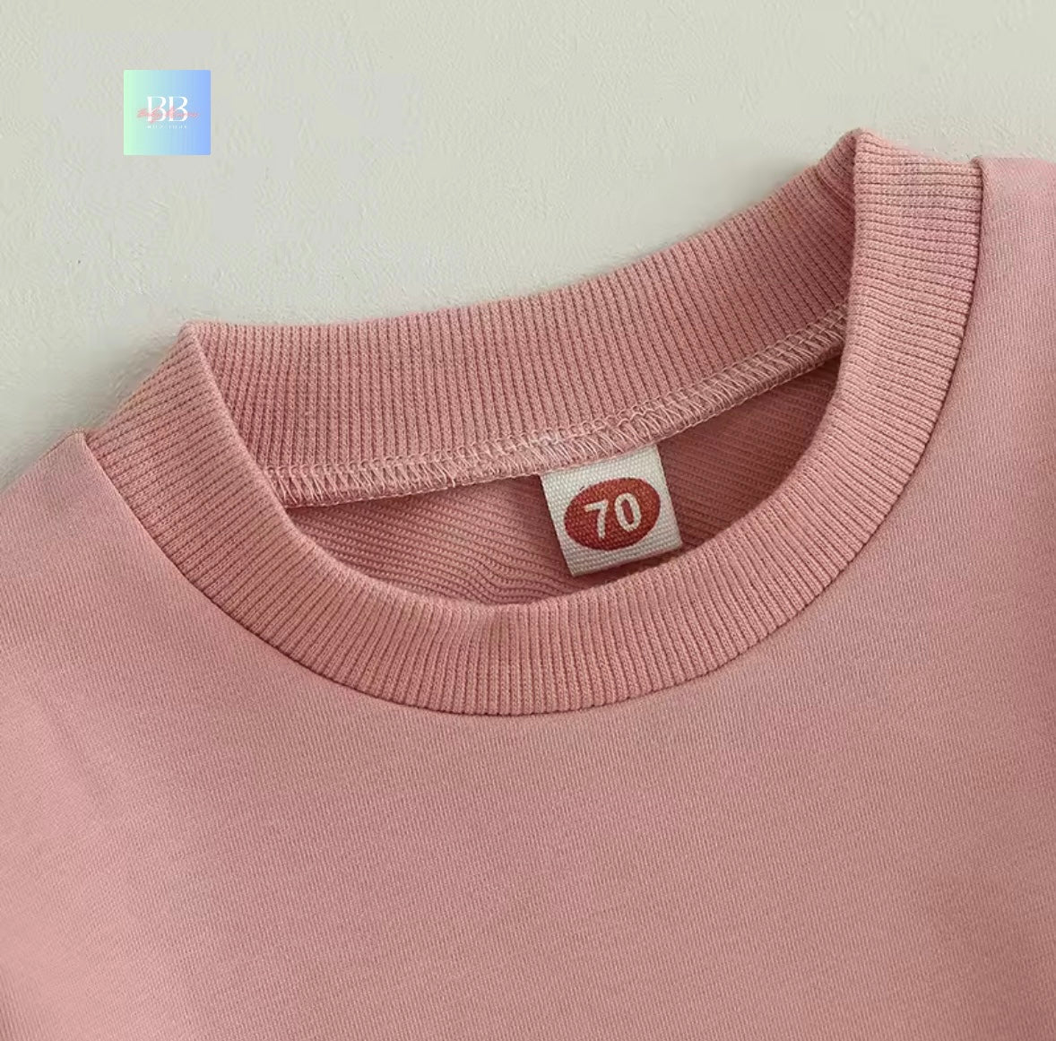 Close-up of a pink garment with a label on a light gray background