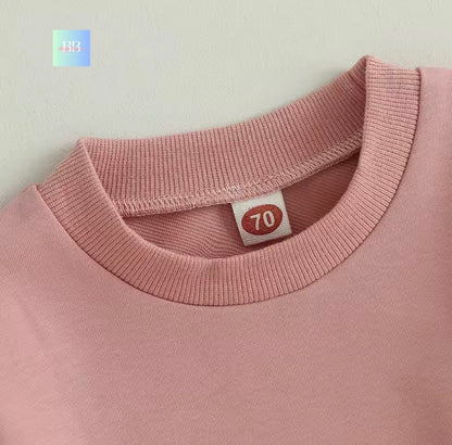 Close-up of a pink garment with a label on a light gray background