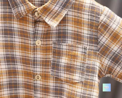 Close-up of a plaid shirt with brown, white, and gray pattern.