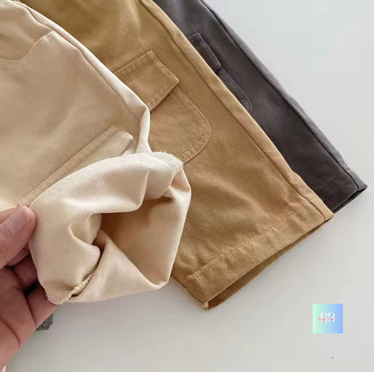 Close-up of beige pants with a hand holding a piece of fabric on a light background