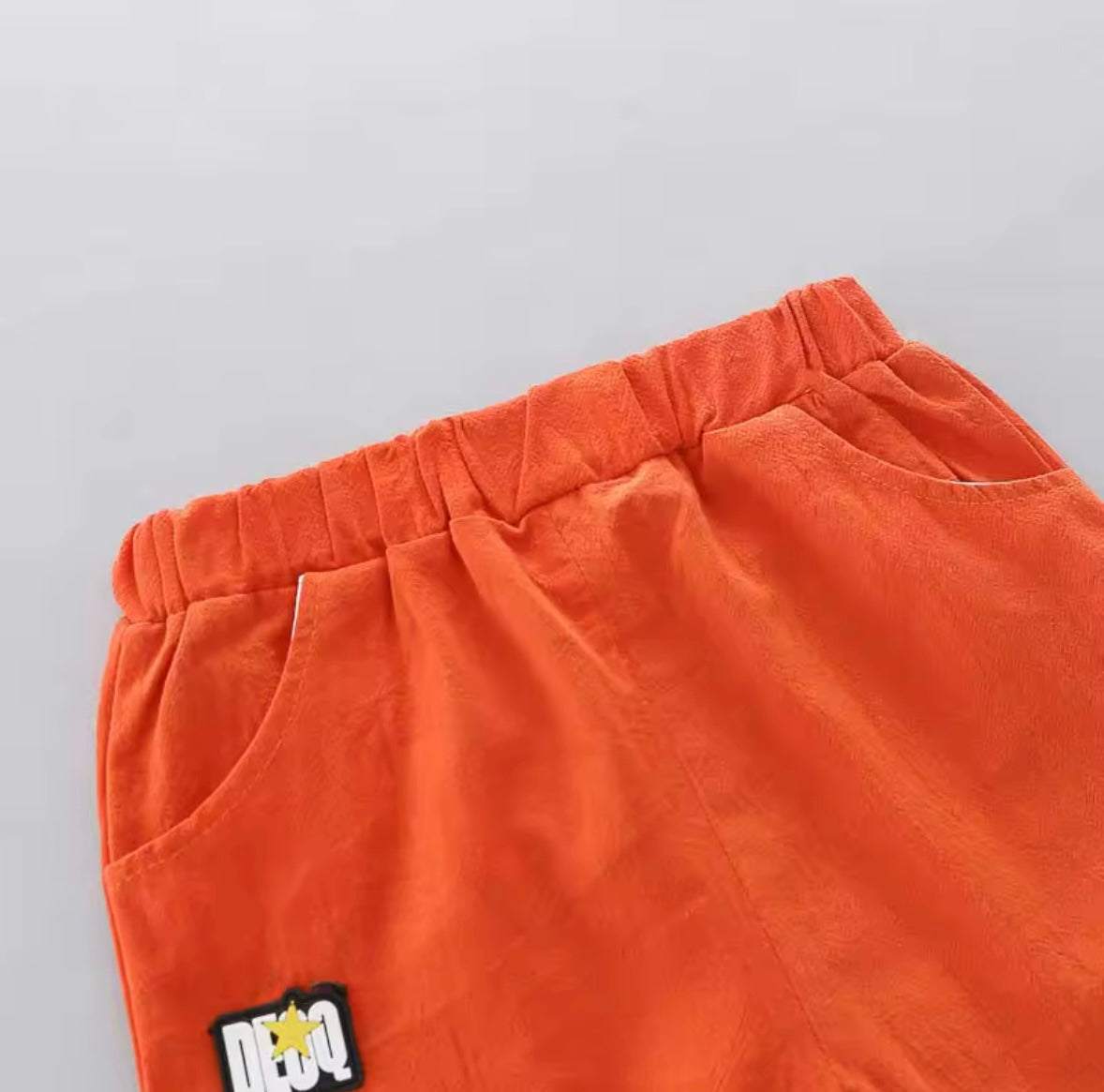 Orange pants with a logo on a gray background