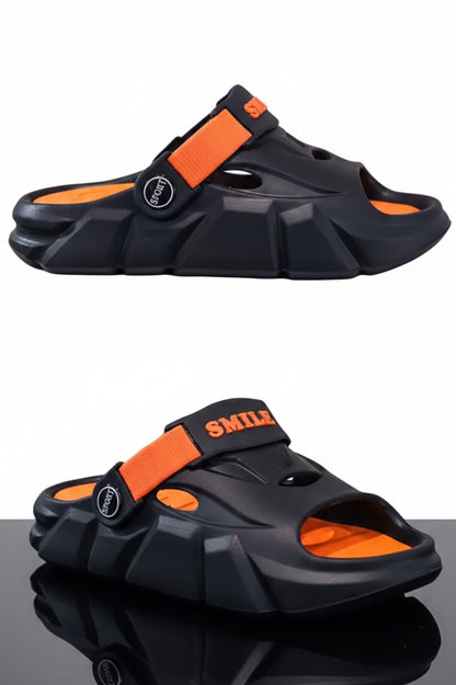 Black and orange sandals on a reflective surface with a neutral background