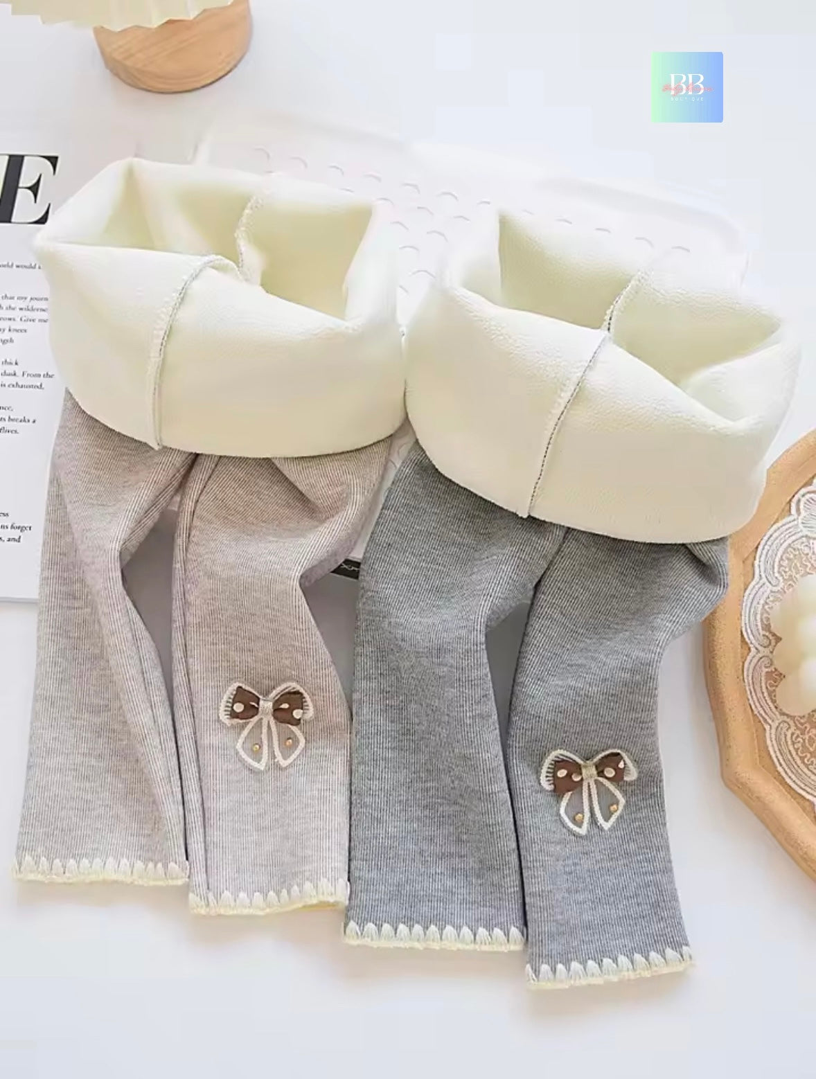 Gray baby pants with white bows on a light background