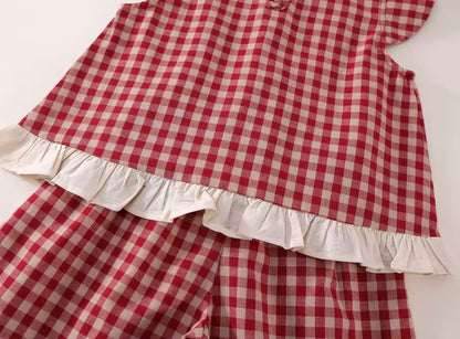 Red and white checkered outfit with ruffled details on a white background