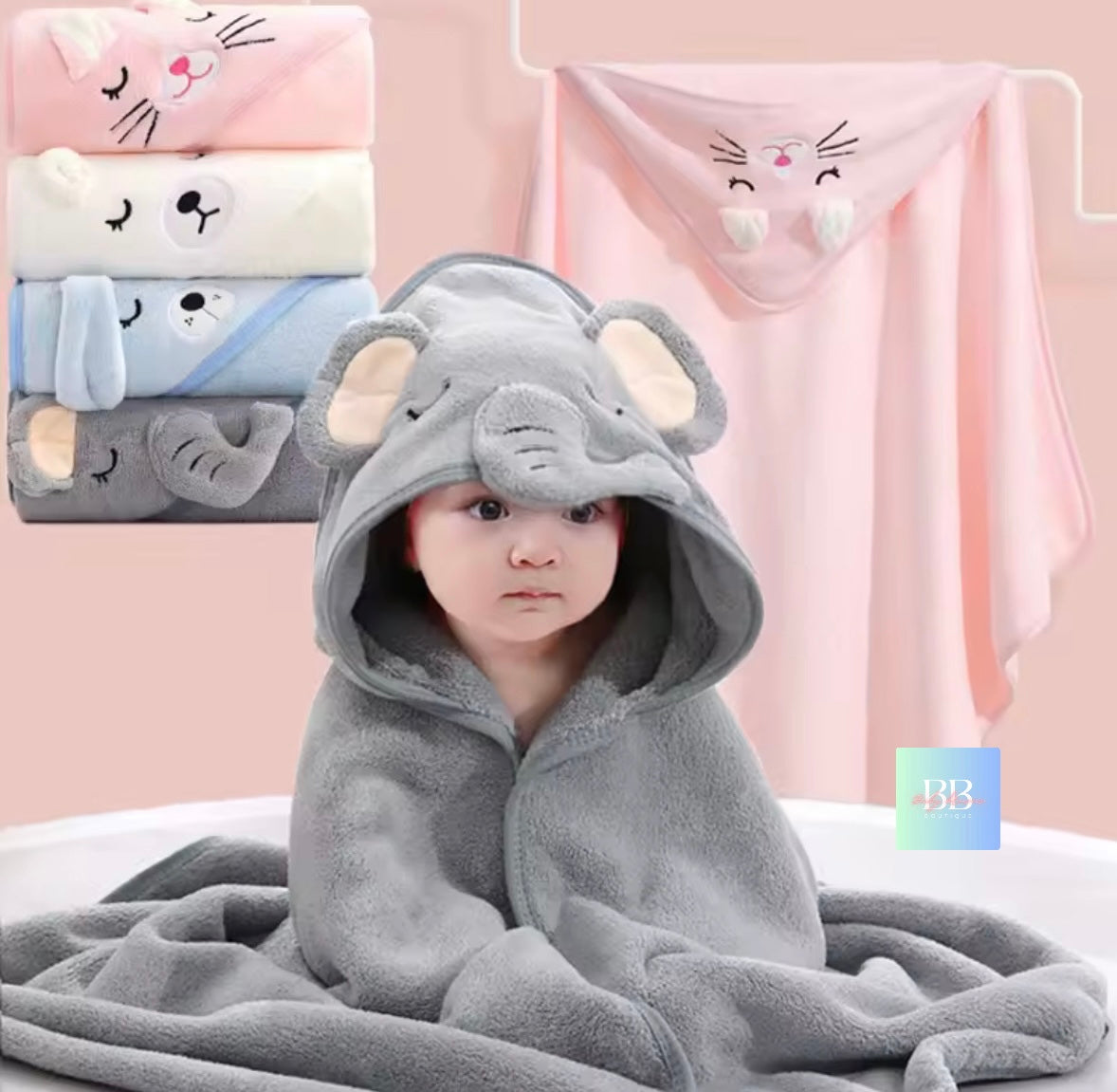 Child wearing a gray elephant hooded towel with cartoon animal designs in the background.