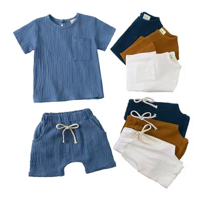 Children's clothing set with blue shirt, shorts, and pants on a white background