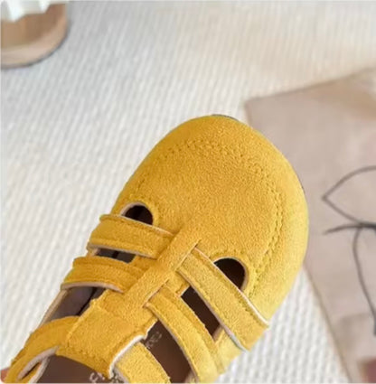 Yellow children's shoe with a strap on a light background