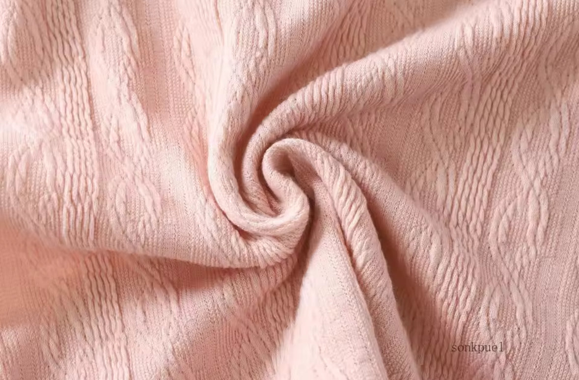 Close-up of pink textured fabric with a swirl pattern