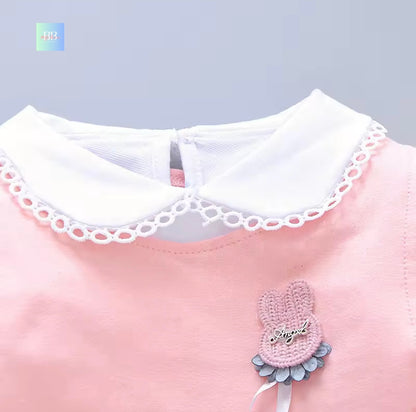 Pink dress with white lace collar and decorative bow on a gray background