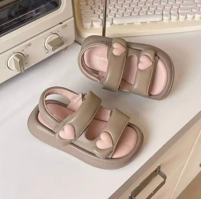 Pair of heart-shaped sandals on a kitchen counter with a keyboard in the background.