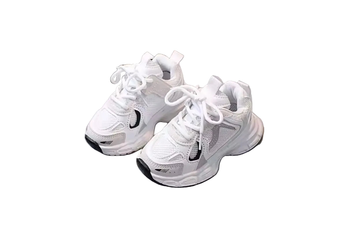 Pair of white sneakers on a light gray surface with a blurred background