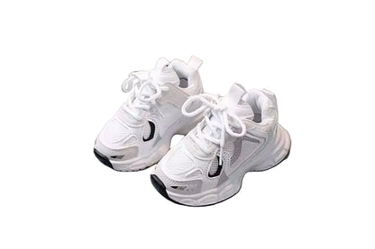 Pair of white sneakers on a light gray surface with a blurred background