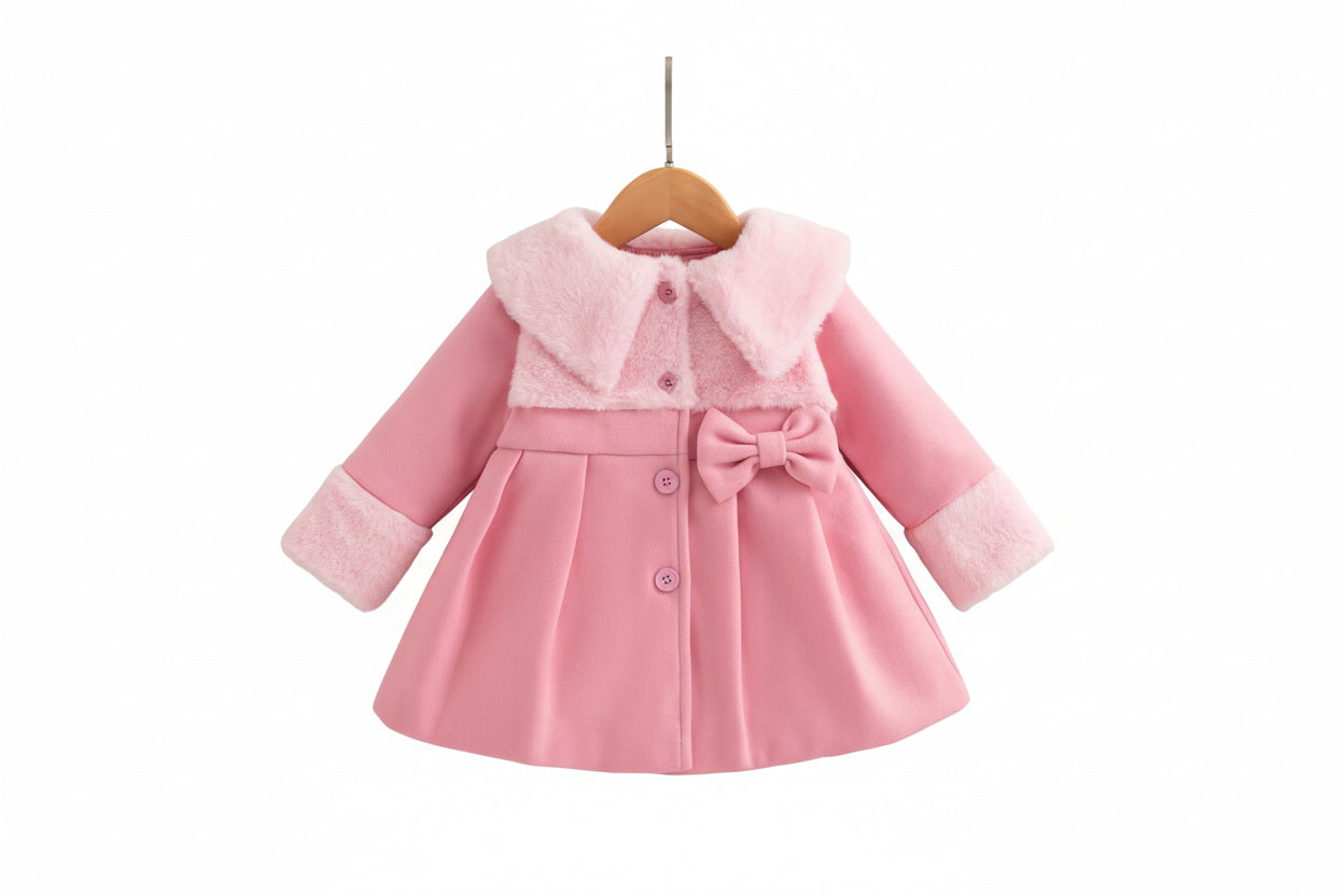 Pink children's coat with white shoes on a wooden surface