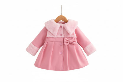 Pink children's coat with white shoes on a wooden surface