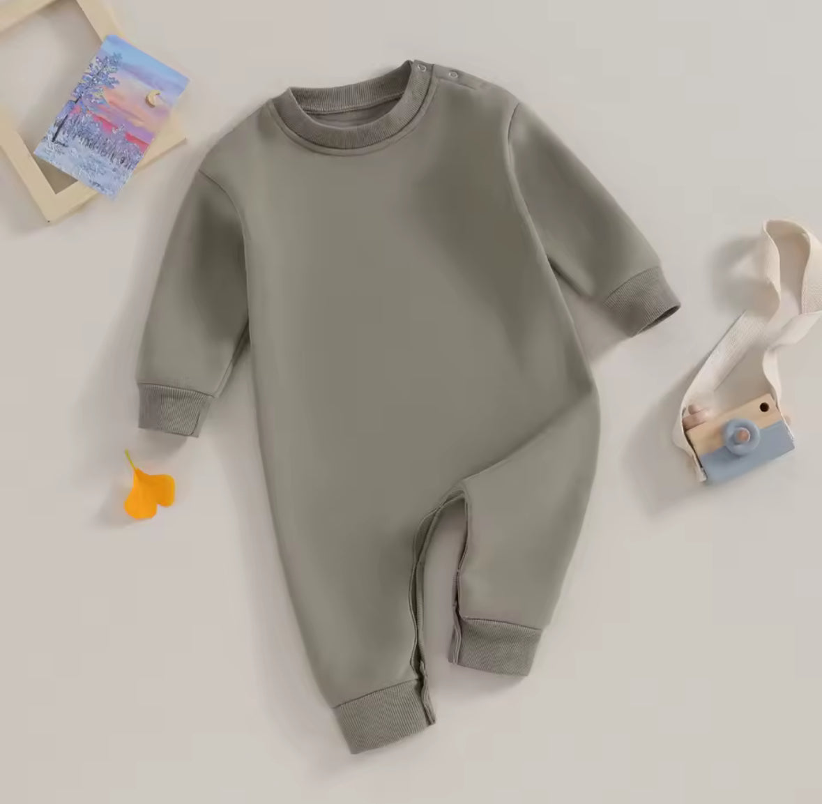 Gray baby onesie on a light beige background