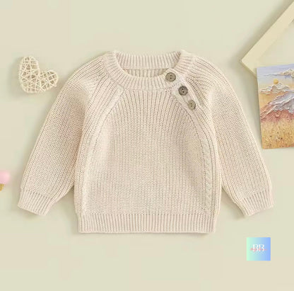 Knitted baby sweater with buttons on a light background