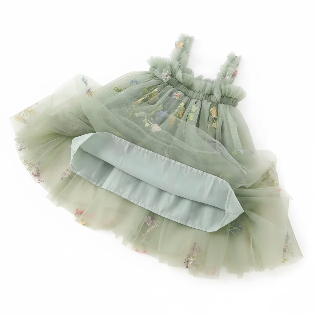 Green dress with floral embroidery on a textured surface