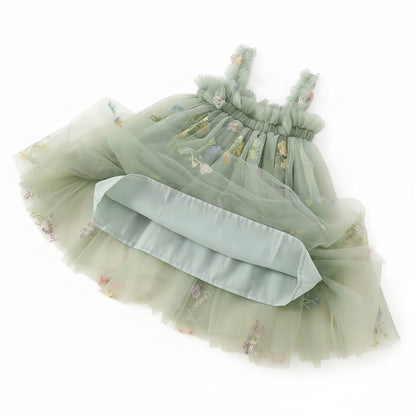 Green dress with floral embroidery on a textured surface