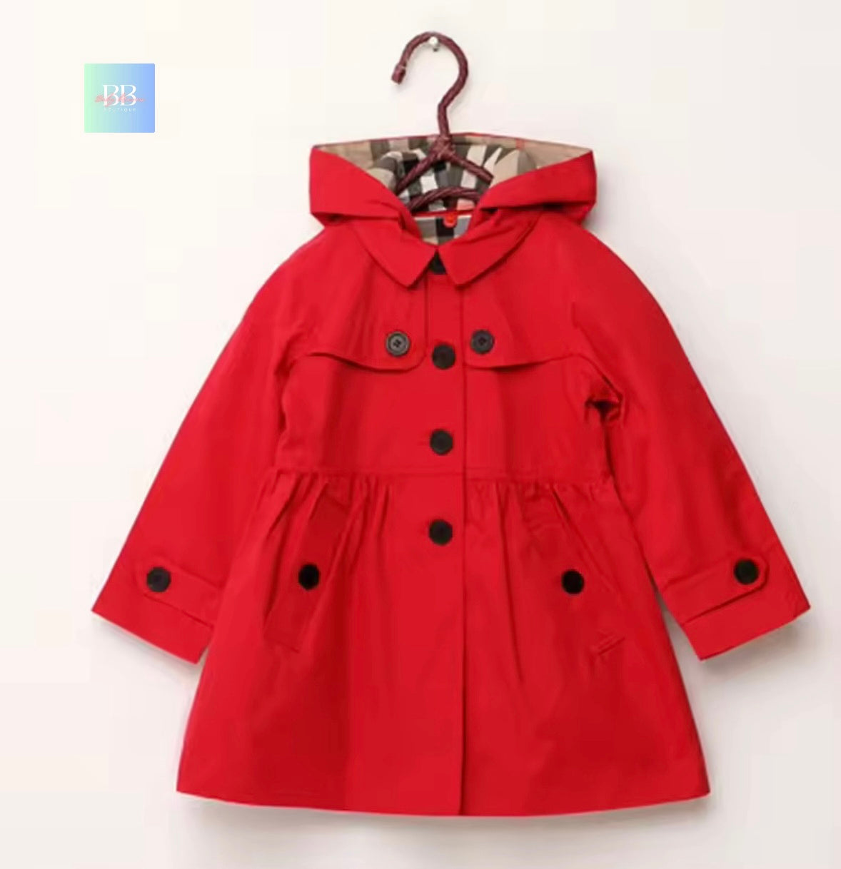 Red children's coat with black buttons on a white background
