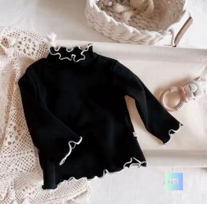 Black long-sleeve top with lace details on a white surface