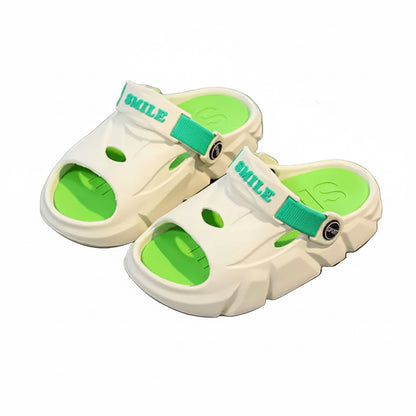 White sandals with green soles on a gray surface