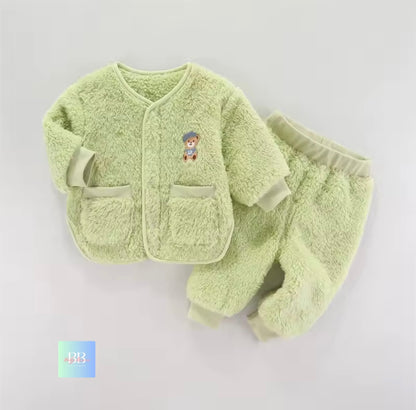 Light green baby outfit with a teddy bear design on a light gray background
