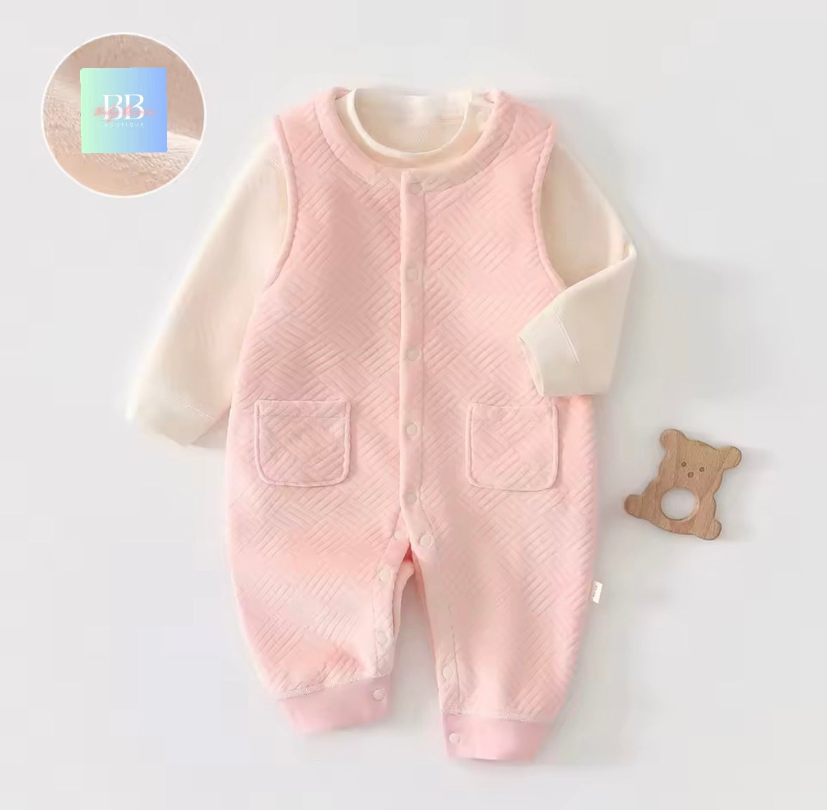 Pink baby romper with white sleeves on a light gray background