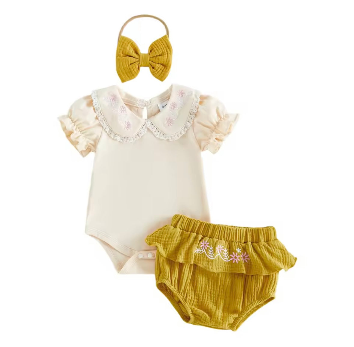 Baby outfit set with bodysuit, bloomers, and headband on a white background