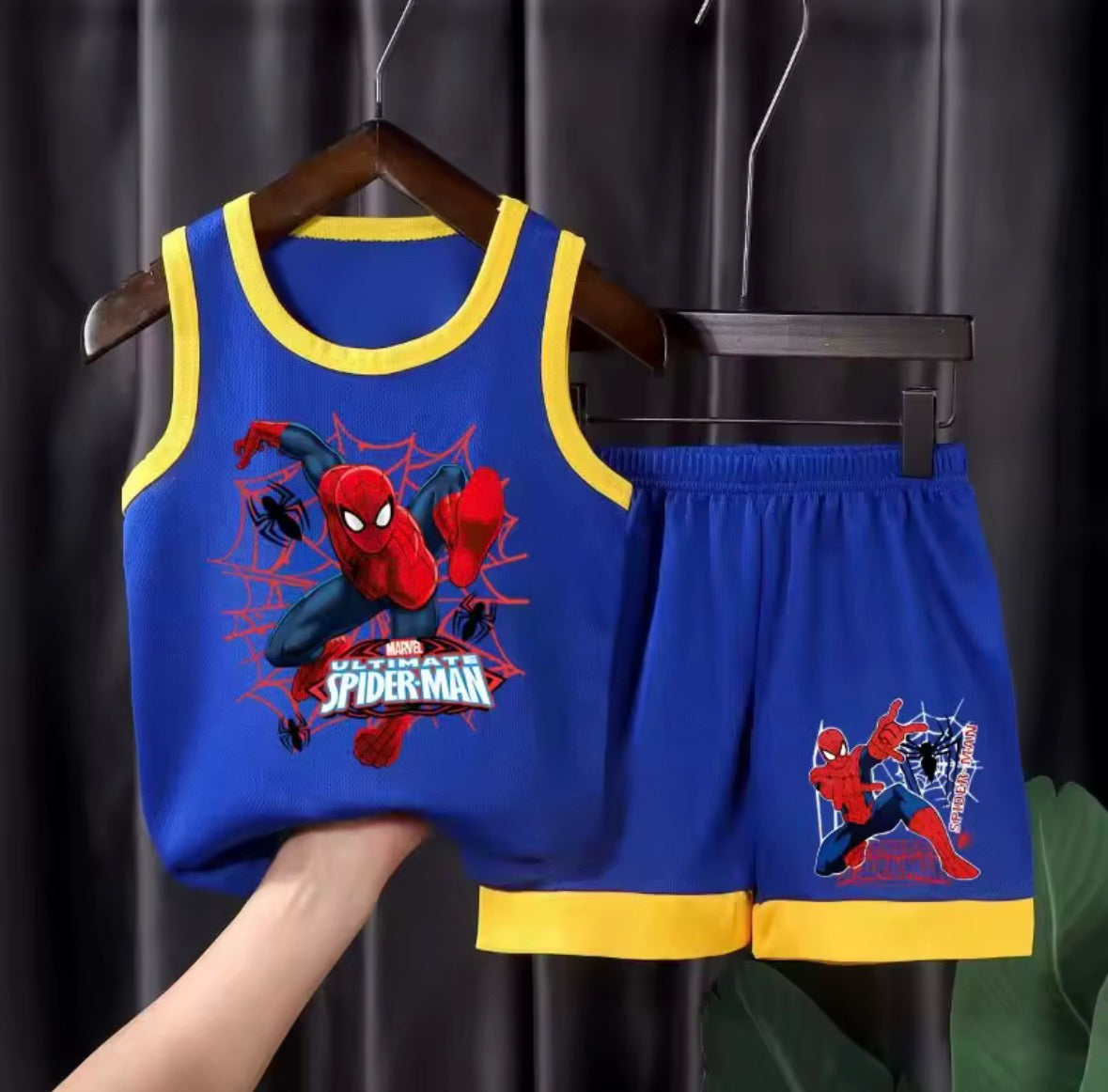 Children's Spider-Man tank top and shorts set on a hanger against a dark background.