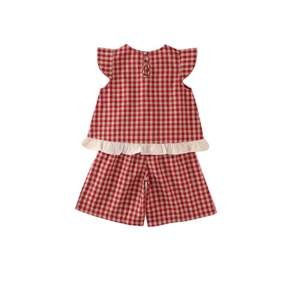 Red and white checkered outfit with a top and shorts on a light beige background
