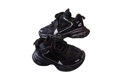 Black sneakers on a white platform with a wooden floor background