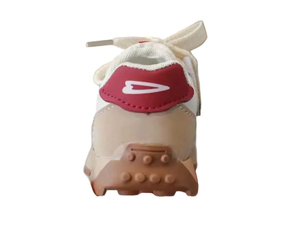 Small model of a sneaker with a red swoosh logo held by a hand.