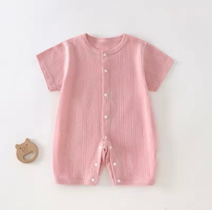 Pink baby romper with buttons on a white background