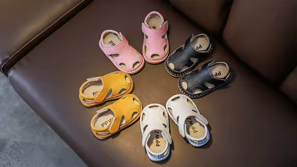 Set of children's sandals in various colors on a brown surface