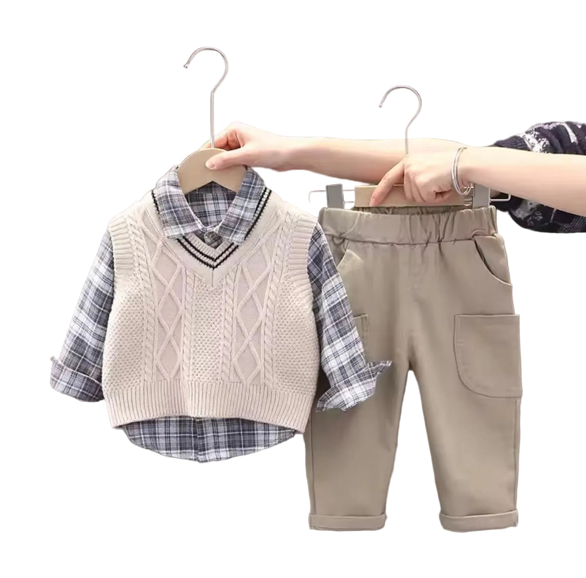 Children's clothing set with vest, shirt, and pants on hangers against a neutral background