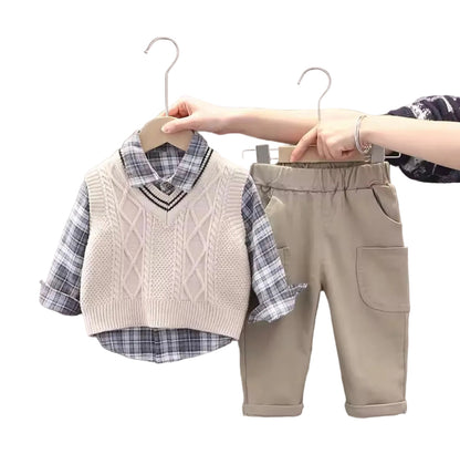 Children's clothing set with vest, shirt, and pants on hangers against a neutral background