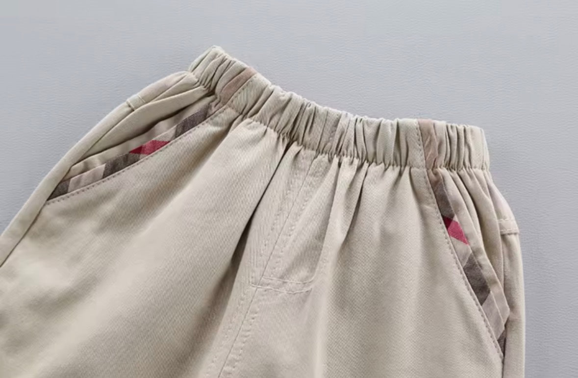 Close-up of beige pants with an elastic waistband on a gray background