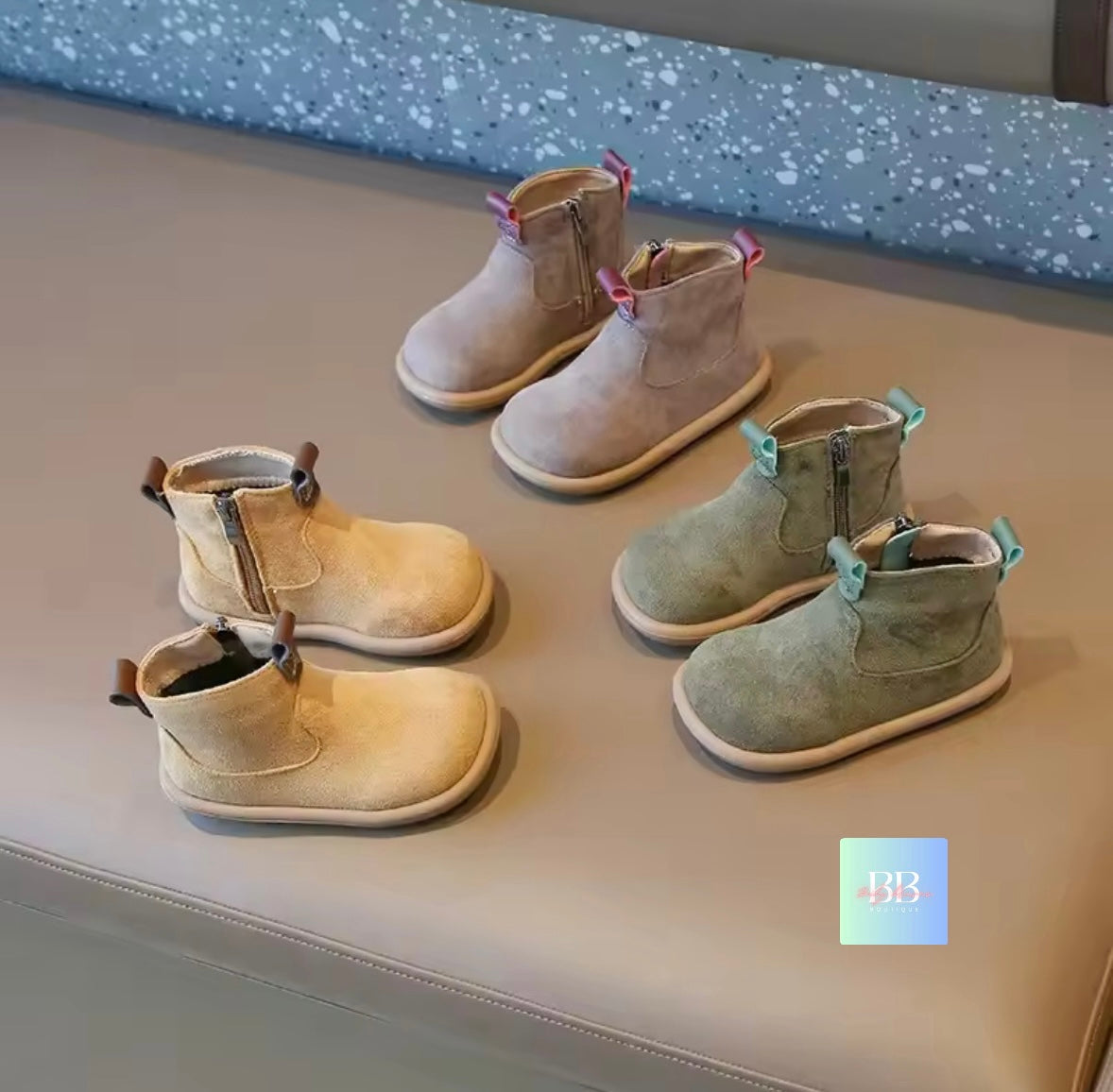 Set of children's boots on a gray surface with a blue textured background