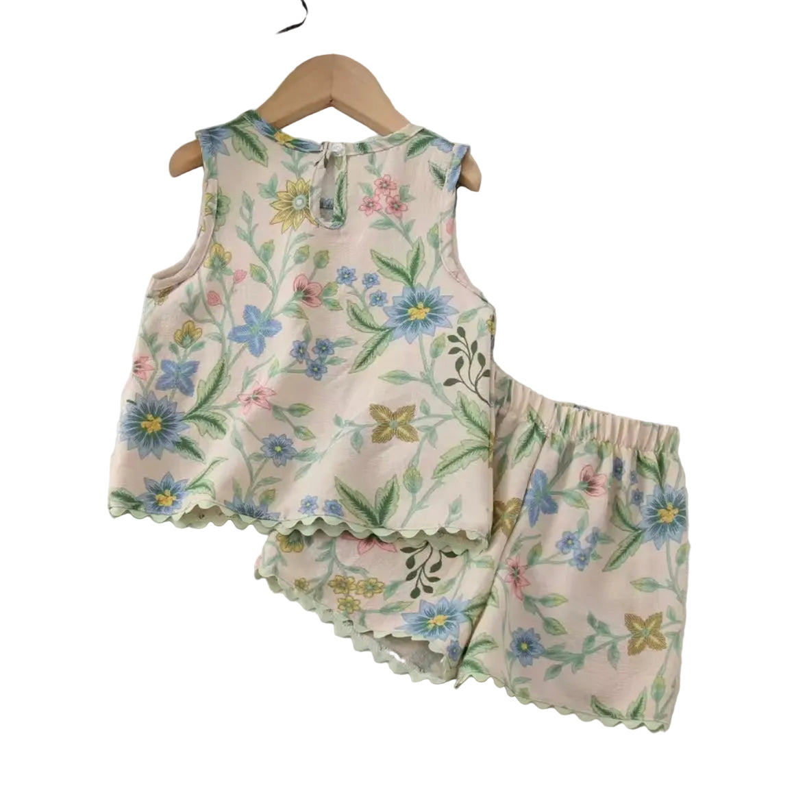 Floral sleeveless top and pants set hanging on a white surface.