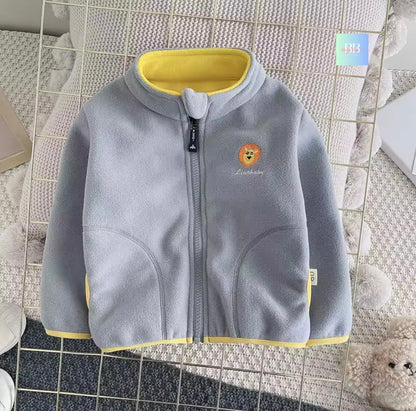 Gray children's fleece jacket with yellow trim on a textured surface