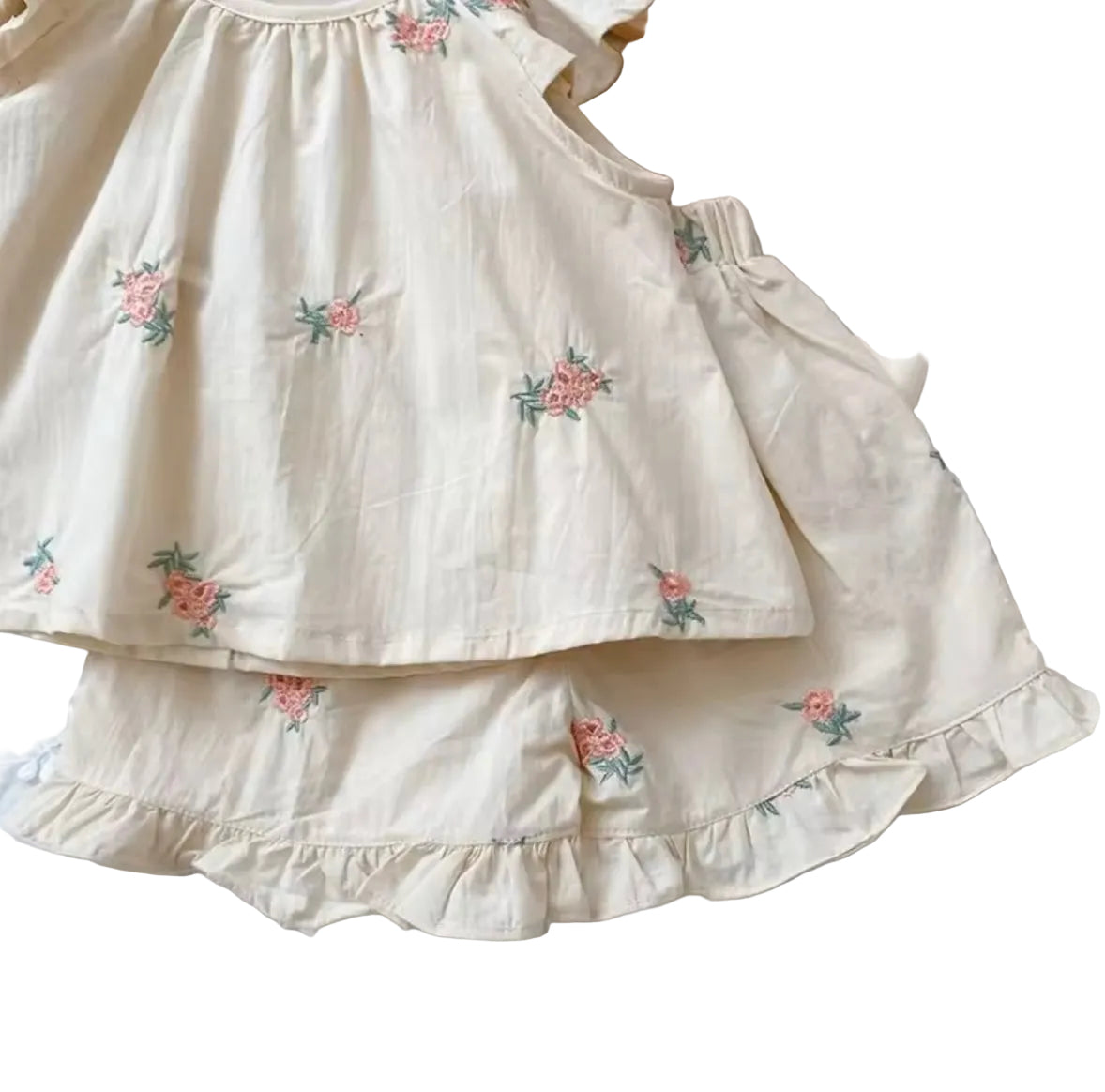 Beige dress with floral embroidery on a textured surface