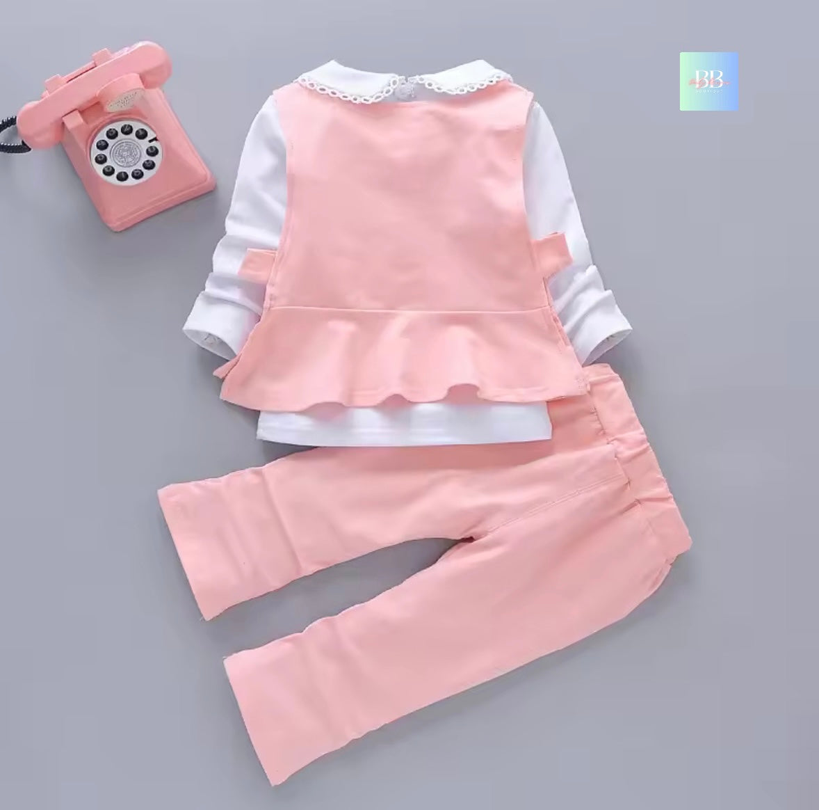 Children's pink outfit with white shirt on a gray background