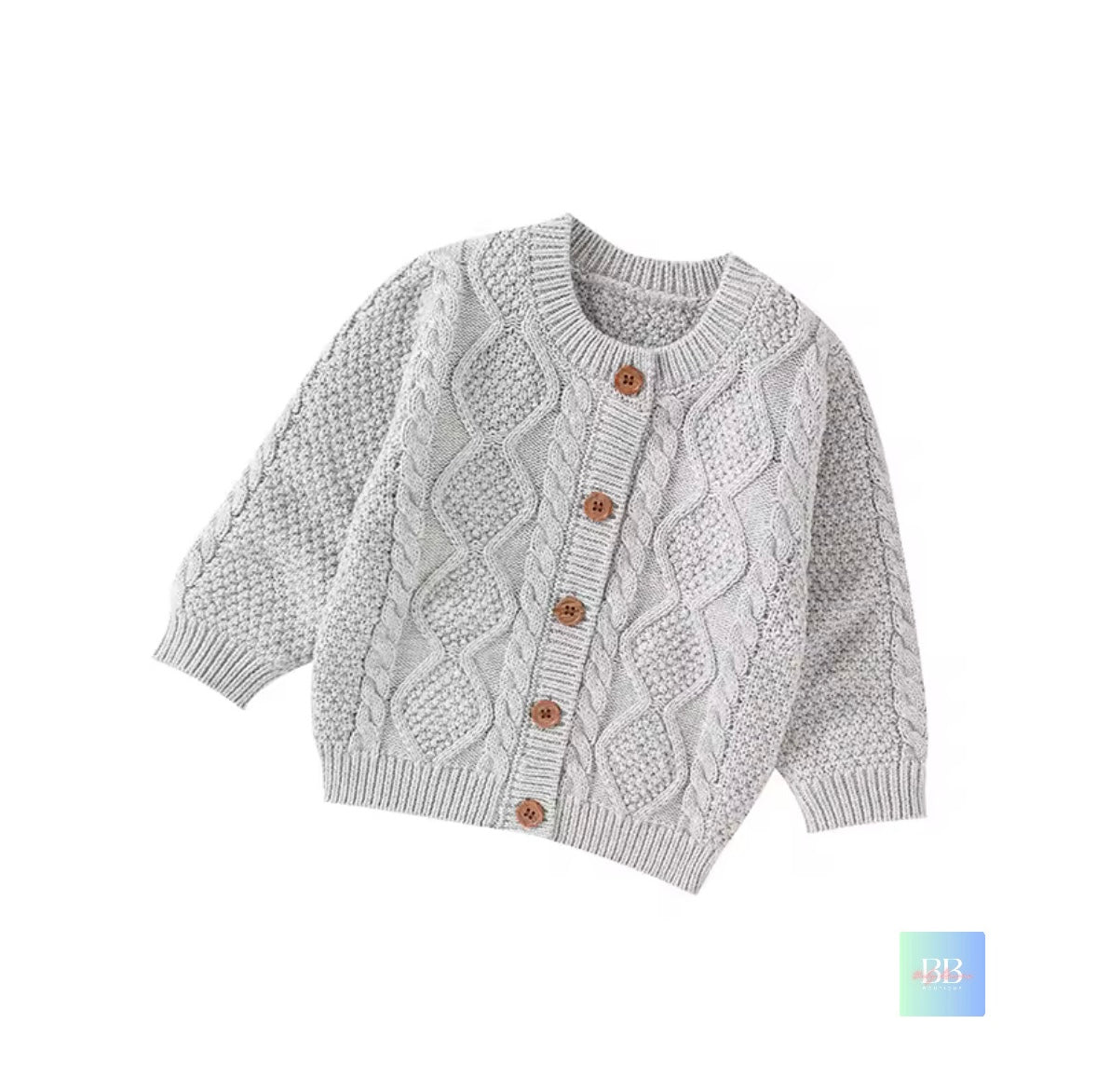 Children's cable knit cardigan with brown buttons on a white background