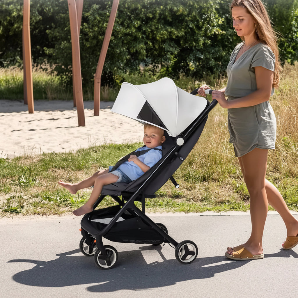 Woman pushing a stroller with a child inside, outdoors.